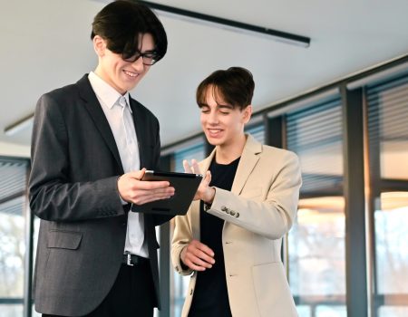 Two young workers discussing business affairs using a tablet in an office